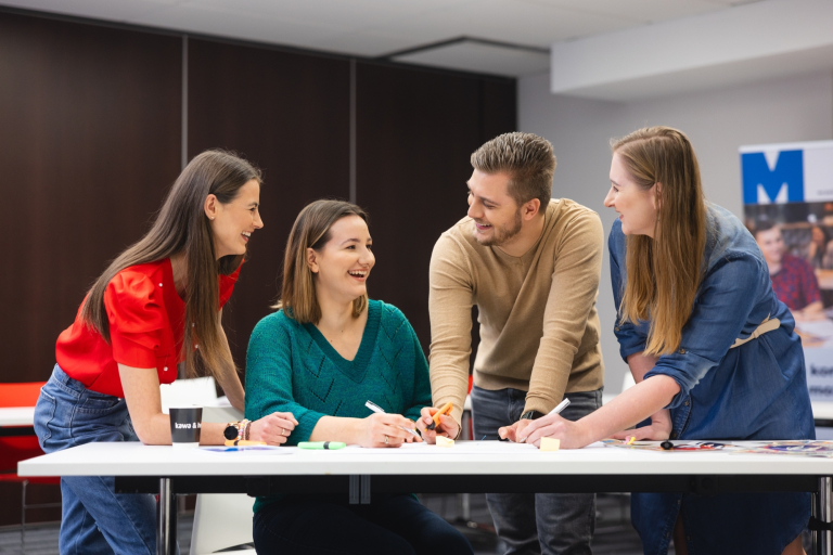 Dietetyka | Studia I stopnia w Toruniu | Uniwersytet WSB Merito w Toruniu: Główna grafika: Toruń - studia I stopnia - grupa uśmiechniętych studentów podczas projektu