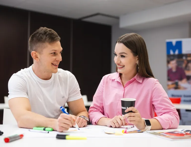 Projektowanie marki i wizerunku firmy | Studia I stopnia w Toruniu | Uniwersytet WSB Merito w Toruniu: Główna grafika: Toruń - studia I stopnia - uśmiechnięci studenci podczas rozmowy