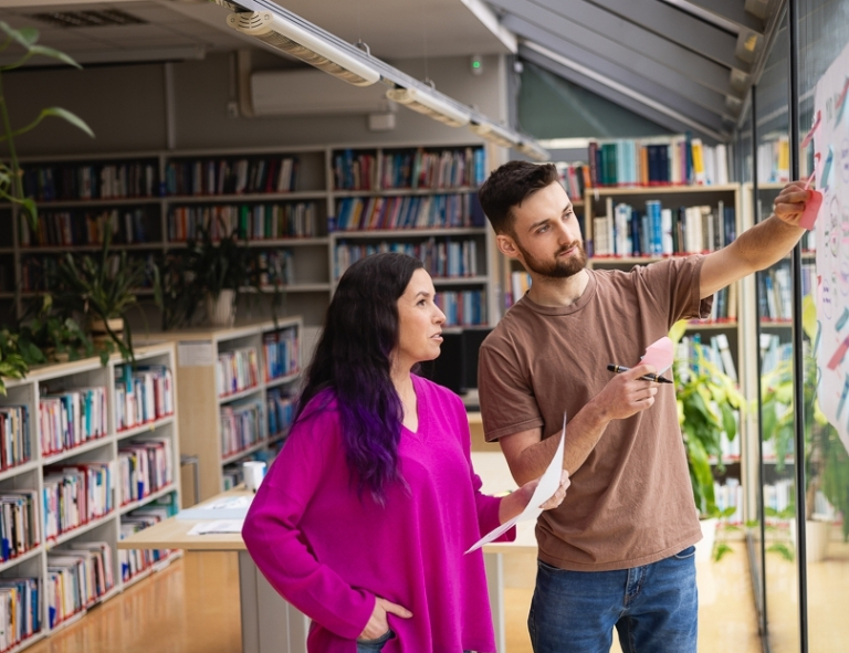 Media i komunikacja w biznesie | Studia I stopnia w Toruniu | Uniwersytet WSB Merito w Toruniu: Główna grafika: Toruń - studia I stopnia -dwójka studentów w bibliotece