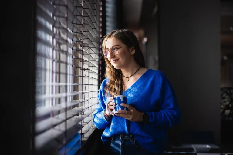 IT Project Manager | Studia I stopnia w Toruniu | Uniwersytet WSB Merito w Toruniu: studentka patrzy przez okno Uniwersytetu WSB Merito w Toruniu