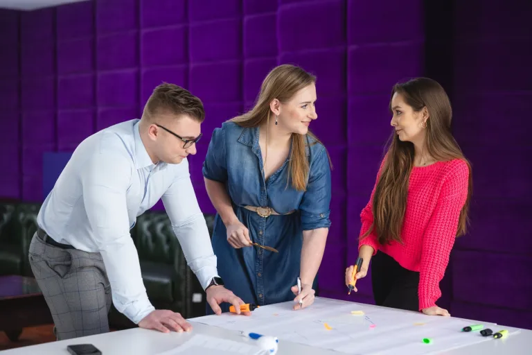 Inżynieria produkcji | Studia II stopnia ze studiami podyplomowymi  | Uniwersytet WSB Merito w Toruniu: Główna grafika: Toruń - studia I stopnia - grupa uśmiechniętych studentów rozmawiająca przy projekcie