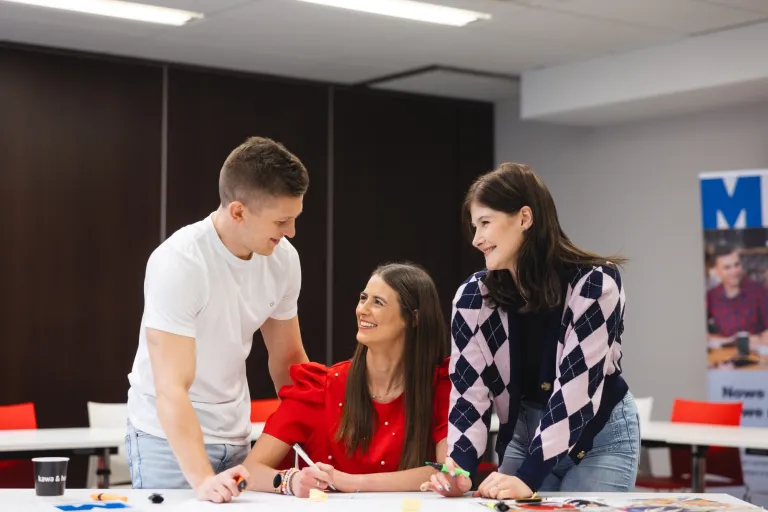 Inżynier zarządzania procesami produkcyjnymi | Uniwersytet WSB Merito w Toruniu: Główna grafika: Toruń - studia I stopnia - grupa uśmiechniętych studentów w sali zajęciowej