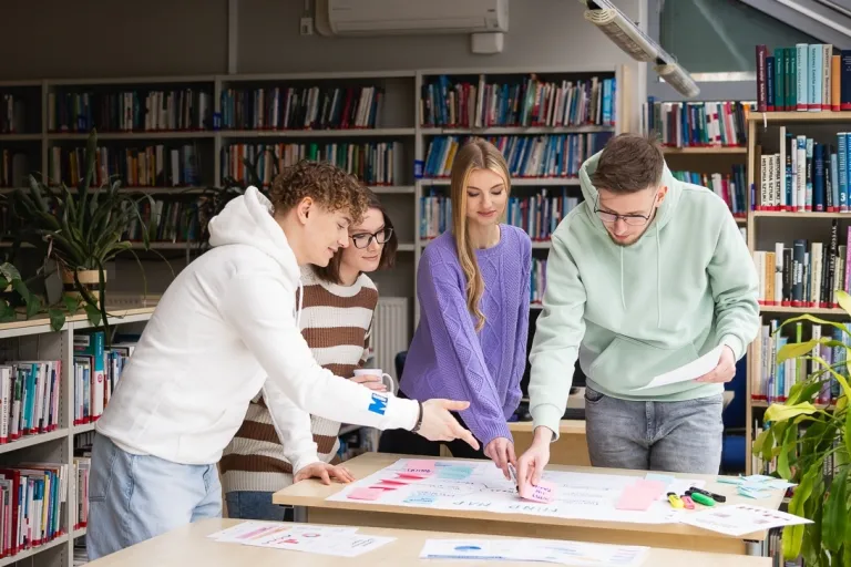 Zarządzanie kryzysowe i ochrona ludności | Uniwersytet WSB Merito w Toruniu: Główna grafika: Toruń - studia I stopnia - grupa uśmiechniętych studentów podczas projektu