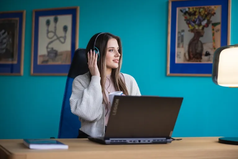 Home Design | Uniwersytet WSB Merito w Toruniu: Główna grafika: Toruń - studia I stopnia - studentka przy laptopie z słuchawkami na głowie