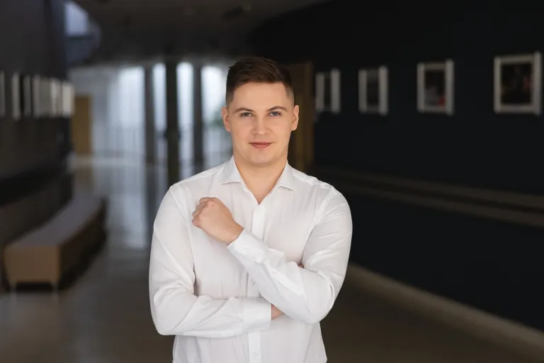 Projektowanie marki i wizerunku firmy | Uniwersytet WSB Merito w Toruniu: Główna grafika: Toruń - studia I stopnia - student w białej koszuli na korytarzu