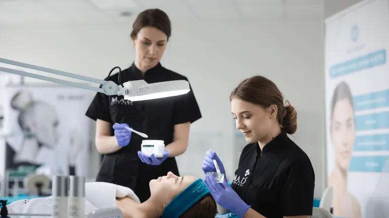 Holistyczna kosmetologia, czyli zdrowie i piękno w praktyce – zapraszamy na wyjątkowe wydarzenie już 14 marca! | Aktualności | Uniwersytet WSB Merito w Toruniu: dwie osoby przeprowadzają zabieg kosmetologiczny