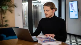 Informatyka | Studia I stopnia w Warszawie | Uniwersytet WSB Merito Warszawa: Informatyk przy biurku