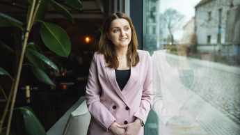 Zwinne zarządzanie projektami – standardy i narzędzia | Studia podyplomowe w Warszawie | Uniwersytet WSB Merito Warszawa: uśmiechnięta kobieta w żakiecie