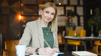 Seksuologia | Studia podyplomowe w Warszawie | Uniwersytet WSB Merito Warszawa: uśmiechnięta kobieta notująca notatki