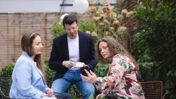 Programowanie aplikacji Java | Uniwersytet WSB Merito Warszawa: trzy osoby patrzące w ekran telefonu