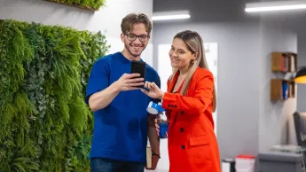 Zarządzanie komunikacją i relacjami w biznesie | Studia II stopnia w Warszawie | Uniwersytet WSB Merito Warszawa: Główna grafika: poznaj WSB Merito Warszawa - studentka i student uśmiechnięci stoją na korytarzu uczelni