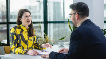 Inżynieria oprogramowania w JavaScript (TypeScript) | Studia podyplomowe w Warszawie | Uniwersytet WSB Merito Warszawa: mężczyzna i kobieta podczas rozmowy