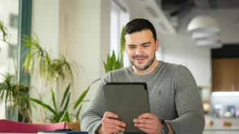 Tworzenie aplikacji internetowych i mobilnych | Uniwersytet WSB Merito Warszawa: mężczyzna pracujący z tabletem