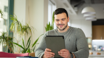 Tworzenie aplikacji internetowych i mobilnych | Studia podyplomowe w Warszawie | Uniwersytet WSB Merito Warszawa: mężczyzna pracujący z tabletem