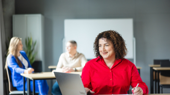 Sztuczna inteligencja i uczenie maszynowe | Studia podyplomowe w Warszawie | Uniwersytet WSB Merito Warszawa: uśmiechnięta kobieta korzystająca z laptopa