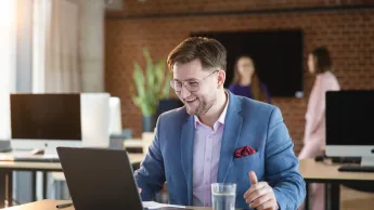 Bankowość cyfrowa | Uniwersytet WSB Merito Warszawa: zadowolony mężczyzna patrzący w ekran laptopa