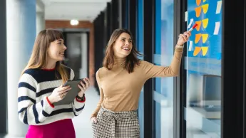 Programowanie aplikacji Java | Uniwersytet WSB Merito Warszawa: dwie kobiety analizujące notatki zapisane na kolorowych karteczkach