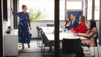 Architekt rozwiązań IT w chmurze obliczeniowej | Studia podyplomowe w Warszawie | Uniwersytet WSB Merito Warszawa: grupa ludzi słuchająca przedstawienia projektu