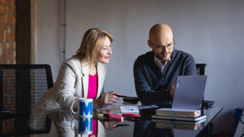 International Payroll and HR | Studia podyplomowe w Warszawie | Uniwersytet WSB Merito Warszawa: kobieta i mężczyzna patrzący w ekran laptopa