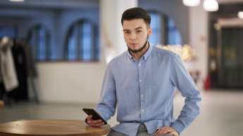 Akademia trenera | Studia podyplomowe w Warszawie | Uniwersytet WSB Merito Warszawa: mężczyzna trzymający telefon w ręce