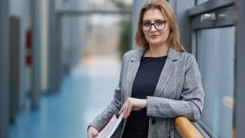 Psychologia w biznesie | Studia podyplomowe w Warszawie | Uniwersytet WSB Merito Warszawa: uśmiechnięta kobieta trzymająca książki