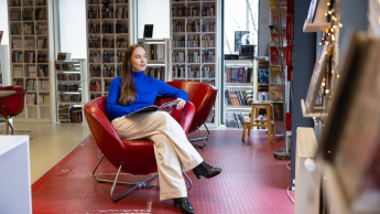 ESG i zrównoważony rozwój | Uniwersytet WSB Merito Warszawa: Studentka relaksuje się w bibliotece.