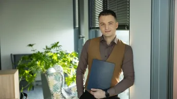 Employer Branding | Studia podyplomowe w Warszawie | Uniwersytet WSB Merito Warszawa: Student WSB Merito trzyma dyplom w ręce z uśmiechem na twarzy