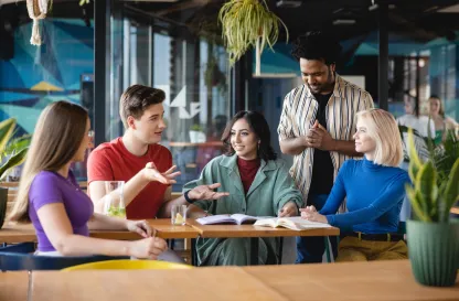 Aktualności | Uniwersytet WSB Merito Warszawa: Studenci WSB Merito Warszawa w wesołej atmosferze rozmawiają przy stoliku