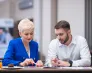 Wakacyjne godziny pracy działów obsługowych | Aktualności | Uniwersytet WSB Merito Warszawa: Student i wykładowca rozmawiają o projekcie.