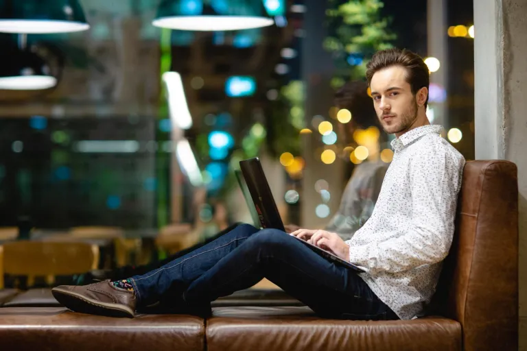 Zarządzanie infrastrukturą ICT - dla inżynierów | Studia II stopnia w Warszawie | Uniwersytet WSB Merito Warszawa: Siedzący student z laptopem