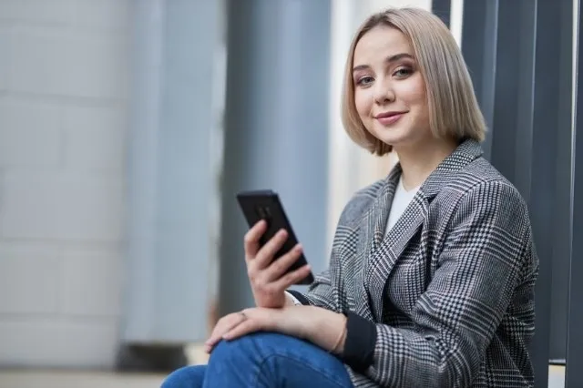 Ekonomia | Studia II stopnia ze studiami podyplomowymi w Warszawie | Uniwersytet WSB Merito Warszawa: Studentka z telefonem