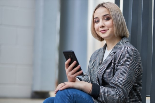 Ekonomia | Studia II stopnia ze studiami podyplomowymi w Warszawie | Uniwersytet WSB Merito Warszawa: Studentka z telefonem