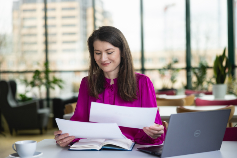 Akademia trenera | Studia podyplomowe w Warszawie | Uniwersytet WSB Merito Warszawa: kobieta przeglądająca dokumenty