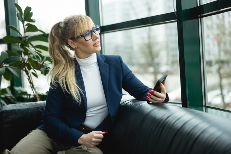 Sztuczna inteligencja w biznesie | Studia podyplomowe w Warszawie | Uniwersytet WSB Merito Warszawa: kobieta trzymająca telefon w ręce