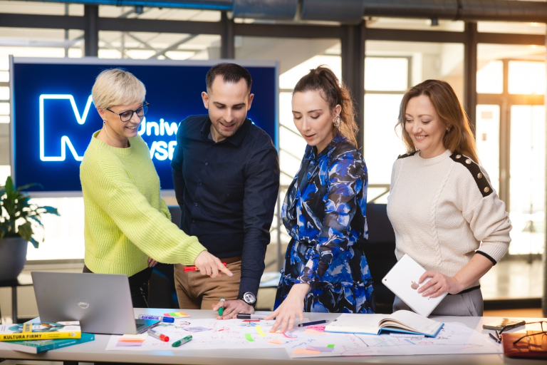 Psychologia pozytywna stosowana | Studia podyplomowe w Warszawie | Uniwersytet WSB Merito Warszawa: grupa ludzi omawiająca projekt