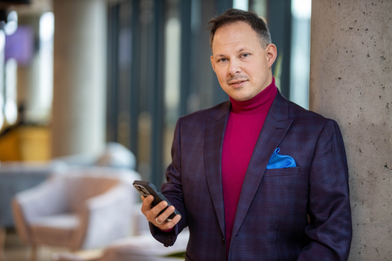 Inżynieria oprogramowania w JavaScript (TypeScript) | Studia podyplomowe w Warszawie | Uniwersytet WSB Merito Warszawa: mężczyzna trzymający telefon w ręce