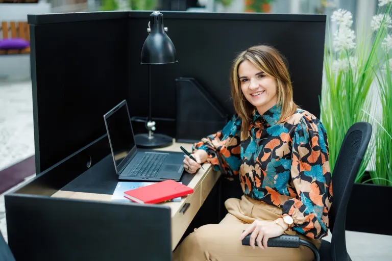 Big Data. Inżynieria Danych | Studia podyplomowe w Warszawie | Uniwersytet WSB Merito Warszawa: uśmiechnięta kobieta przy komputerze