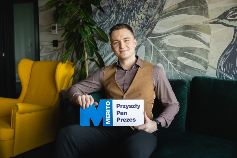 "Potrafię się obronić" – sprawdź, jak ogarnąć stres przed obroną! 🎓 | Aktualności | Uniwersytet WSB Merito Warszawa: Student z tabliczką