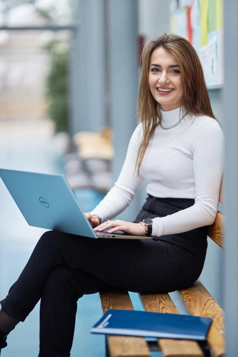 Bezpieczeństwo i higiena pracy | Studia I stopnia w Warszawie | Uniwersytet WSB Merito Warszawa: Siedząca studentka z laptopem