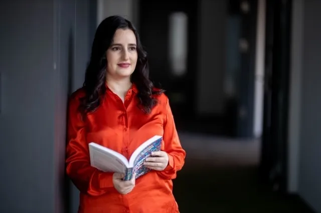 E-biznes | Uniwersytet WSB Merito Warszawa: Stojąca studentka z książką 