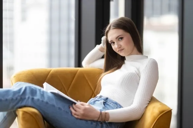 Informatyka | Studia II stopnia w Warszawie | Uniwersytet WSB Merito Warszawa: Studentka siedząca na fotelu z notatkami