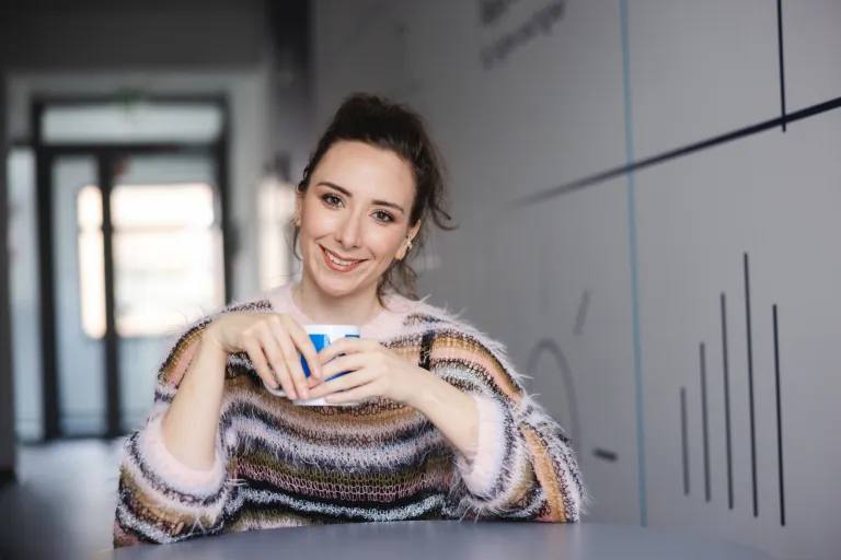 Customer experience i zarządzanie relacjami z klientem | Studia I stopnia w Warszawie | Uniwersytet WSB Merito Warszawa: uśmiechnięta kobieta trzymająca kubek w rękach