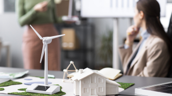 Energetyka wiatrowa | Studia podyplomowe we Wrocławiu | Uniwersytet WSB Merito we Wrocławiu: Model turbiny wiatrowej z osobami w tle