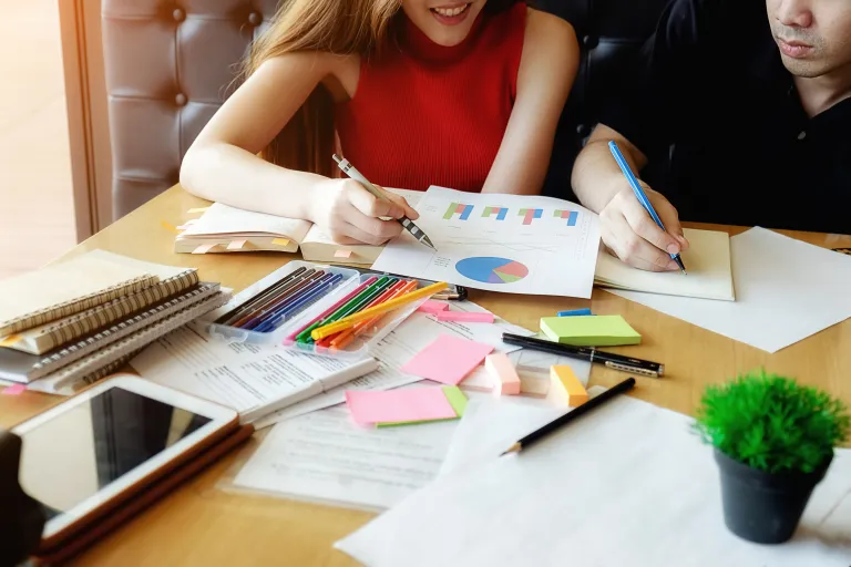 Prawo dla menedżera, studia podyplomowe: Para studentów analizuje wspólnie wykres kołowy