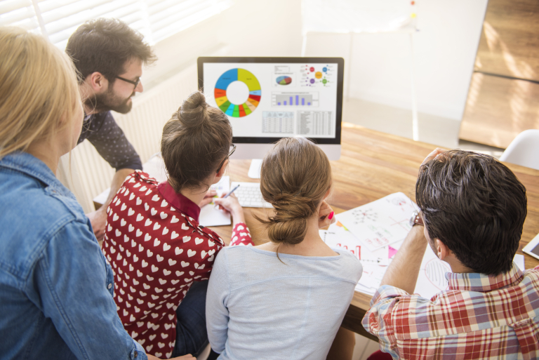 Cloud Solution Architect | Studia podyplomowe we Wrocławiu | Uniwersytet WSB Merito we Wrocławiu: Grupa osób analizuje dane na wykresie przy komputerze