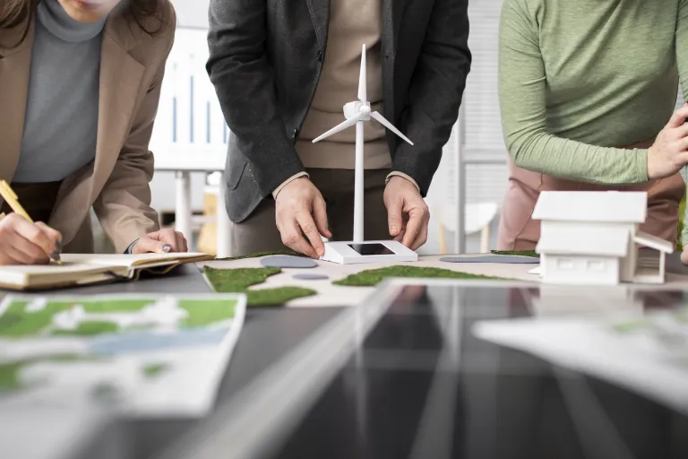 EKOnferencja 2025. Turystyka przyjazna przyrodzie | Uniwersytet WSB Merito we Wrocławiu: Grupa osób pracująca przy modelu turbiny wiatrowej