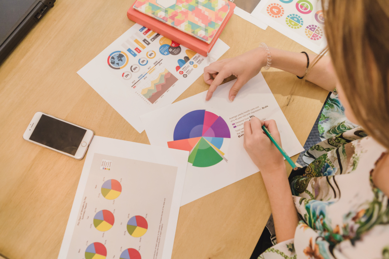 E-commerce | Studia I stopnia we Wrocławiu | Uniwersytet WSB Merito we Wrocławiu: Kobieta analizuje dane na wykresie z ołówkiem w dłoni