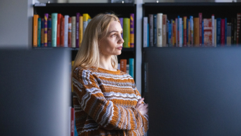 Zarządzanie kryzysowe | Studia podyplomowe we Wrocławiu | Uniwersytet WSB Merito we Wrocławiu: uczestniczka studiów podyplomowych patrząca przez okno w bibliotece