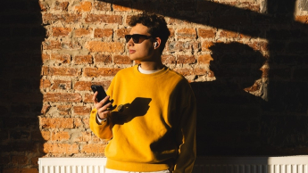 Content marketing | Studia I stopnia we Wrocławiu | Uniwersytet WSB Merito we Wrocławiu: student w okularach przeciwsłonecznych, patrzący przez okno