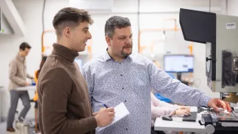 Inżynieria systemów i technologii cyfrowych w logistyce | Studia I stopnia we Wrocławiu | Uniwersytet WSB Merito we Wrocławiu: student i wykładowca podczas zajęć w pracowni inżynierskiej